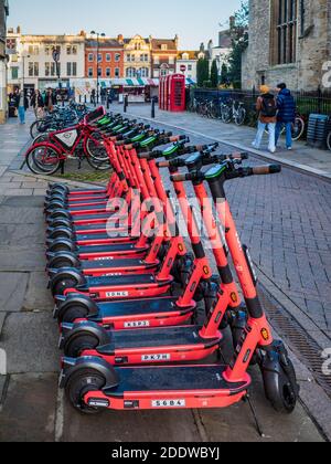 Location de scooters électriques VOI dans une rue du centre historique de Cambridge. Location de scooters électroniques VOI Technology dans une rue de Cambridge. Banque D'Images