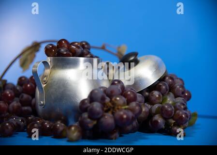 Fruits et baies de raisin frais. Fond bleu . Ingrédient pour les jus et le vin. Baies de raisin en aluminium. Banque D'Images