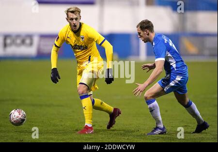 Joe Pigott (à gauche) de l'AFC Wimbledon et Scott Wilson de Barrow se battent pour le ballon lors du premier match de la coupe Emirates FA au stade progression Solicitors, Barrow. Banque D'Images