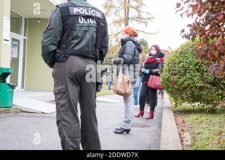 Bardejov, Slovaquie - 31 octobre 2020 : un policier contrôle les gens pour rester à distance de sécurité dans les files d'attente. La Slovaquie tente de faire un test de covid à toute la nation. Banque D'Images