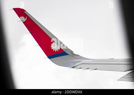 Aile avec logo de l'avion de Nepal Airlines vu de la fenêtre de l'avion. Banque D'Images