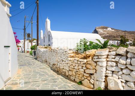 Folegandros, Grèce - 23 septembre 2020 : rue pavée avec une église blanche à Chora sur Folegandros. Cyclades, Grèce Banque D'Images