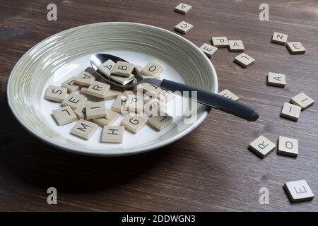 une assiette pleine de lettres sur une table en bois Banque D'Images