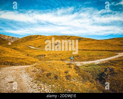 Homme qui va en VTT sur un parcours de montagne - Un jeune motard de montagne qui fait son e-vélo sur une piste À travers les prairies - VTT Banque D'Images