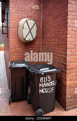 Deux poubelles noires se trouvent à l'extérieur de la maison en brique rouge Nelson Mandela, sur la rue Vilakazi, à Orlando Ouest, à Soweto, en Afrique du Sud. Banque D'Images