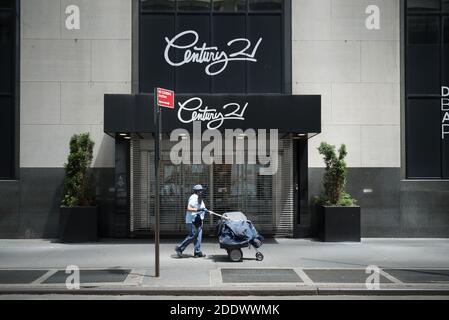 Manhattan, New York. 22 mai 2020. Un transporteur de courrier USPS portant un masque marche devant un magasin Century 21 fermé à Lower Manhattan. Banque D'Images