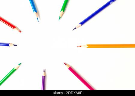 Cercle de crayons de couleur aiguisés. L'accent est mis sur l'espace de copie au centre. Les crayons pointent vers votre texte ou votre idée. Vue de dessus. Banque D'Images