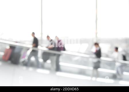 Image floue des personnes (voyageurs) sur l'escalier roulant à l'intérieur du terminal de l'aéroport