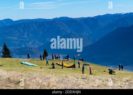 Panorama d'hiver depuis le sommet de Monte Avena. Ciel dégagé et chaînes de montagnes. Les parapentes se préparent au départ, les touristes admirent la vue Banque D'Images