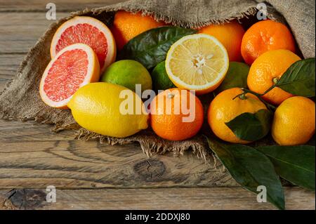 Assortiment d'agrumes de style rustique, oranges, pamplemousses, citrons et limes sur toile de fond en bois Banque D'Images