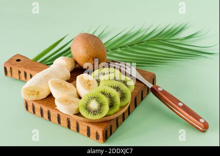 Fruits exotiques tranchés sur une planche à découper en bois, gros plan. Kiwi et banane en lamelles pour la cuisson de smoothie. Riche en vitamines et fruits frais, sain bio Banque D'Images