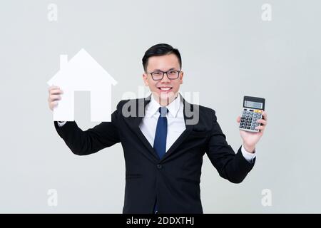 Agent homme asiatique montrant modèle de maison avec calculatrice pour vrai financement immobilier et concept d'investissement Banque D'Images