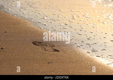 Une empreinte unique sur le sable étincelant. C'est le moment de penser aux plages calmes. Il est préférable de penser à l'avenir en marchant ! Banque D'Images