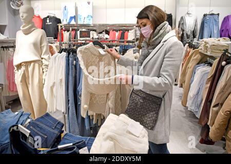 Sujet photo NOIR VENDREDI 26 novembre 2020. Une jeune femme avec masque, masque regarde les textiles, les articles de vêtements dans un magasin de mode en temps de la corona pandémie, le verrouillage, l'arrêt, la valeur d'incidence. MODÈLE DISPONIBLE ! | utilisation dans le monde entier Banque D'Images