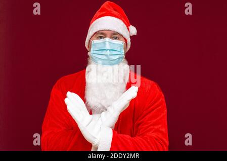 Gros plan santa claus costume rejet expression croisant les bras et les paumes faisant signe négatif, porte le masque médical.image de vue avant. Banque D'Images