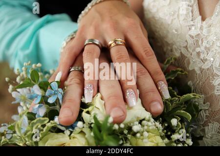 Anneaux de mariage. Main de la mariée avec un anneau tient un bouquet de mariage. Banque D'Images