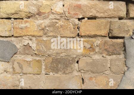 Texture du mur extérieur en brique avec le vieux revêtement tombé. Vieux bâtiment avec plâtre tombant. Arrière-plan du motif de mur de briques Banque D'Images