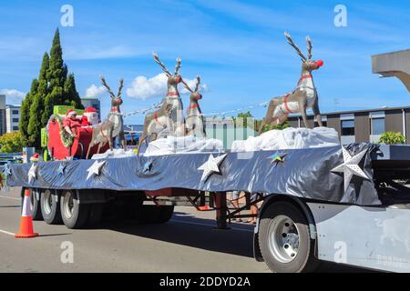 Le Père Noël, Mme Santa, et leur renne sur une parade flottent lors d'une parade de Noël à Rotorua, en Nouvelle-Zélande Banque D'Images