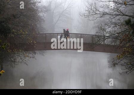 Chippenham, Wiltshire, Royaume-Uni. 27 novembre 2020. Avec de nombreuses régions du Royaume-Uni se réveillant jusqu'à un début brumeux de la journée, un couple poussant un poussette sont photographiés en traversant un pont au-dessus de la rivière Avon à Chippenham, Wiltshire. Credit: Lynchpics/Alamy Live News Banque D'Images