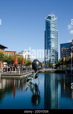 Vue le long d'un quai reconverti en direction de l'immeuble d'appartements numéro 1 Gunwharf Quays à Portsmouth, Hampshire. Le Vernon Monument à la Marine royale d Banque D'Images