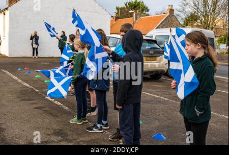 Athelstaneford, East Lothian, Écosse, Royaume-Uni, 27 novembre 2020. Festival de la Saltire : lieu de naissance du drapeau national écossais pour marquer le Saltire Festival qui a précédé la St Andrew’s Day. Les enfants de l'école primaire d'Athelstaneford célèbrent leur connexion au Centre national du patrimoine du drapeau avec des lectures, l'élévation de la saltire et une procession à travers le village dirigé par des enfants P7 Banque D'Images