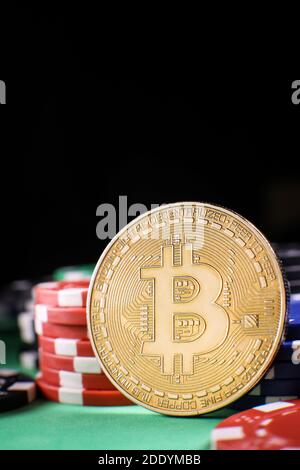 Pièce d'or Bitcoin avec jetons de poker sur une table de poker verte sur fond noir. Blockchain casino. Jeu en ligne. Banque D'Images