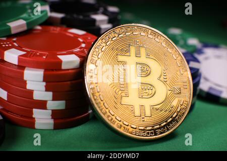 Pièce d'or Bitcoin avec jetons de poker sur une table de poker verte sur fond noir. Blockchain casino. Jeu en ligne. Banque D'Images