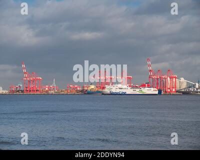 Sur la rivière Mersey, le Stena Ferry passe par les grues de manutention de conteneurs du port de Liverpool, en direction de Belfast en Irlande du Nord. Banque D'Images