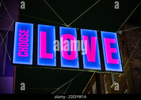 Gros plan de L'affiche illuminée « CHOISIR L'AMOUR » dans le cadre de Le Noël de Carnaby Street 2020 s'illumine pendant le COVID 19 pandémie Banque D'Images