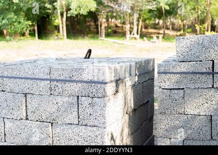 Des blocs de cinder pour construire une maison sont empilés dans un tas, allongé sur la rue. Construction et installation. Banque D'Images