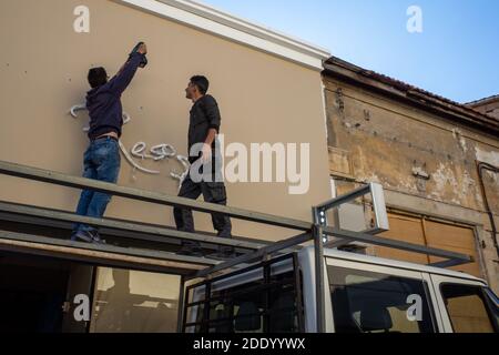 22 avril 2019, Limassol, Chypre. Deux travailleurs installent un panneau de café dans une rue de la ville de Limassol. Banque D'Images