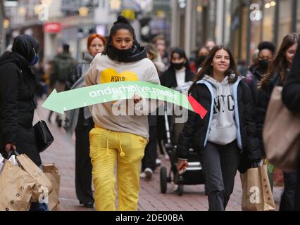 Amsterdam, pays-Bas. 27 novembre 2020. Un employé municipal tient un placa pour les consommateurs afin d'éviter les lieux fréquentés et de garder la distance sociale pendant le « Vendredi noir » sur la place du Dam près de la rue commerçante Kalverstraat, dans le cadre de la pandémie du coronavirus, le 27 novembre 2020, dans le centre-ville d'Amsterdam, aux pays-Bas. (Photo de Paulo Amorim/Sipa USA) Credit: SIPA USA/Alay Live News Banque D'Images