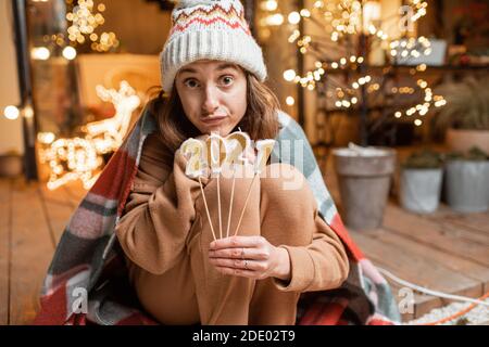 Portrait d'une femme triste en masque facial célébrant seul les fêtes du nouvel an. Tenir les bougies 2021 avec un espoir que la quarantaine prendra fin Banque D'Images