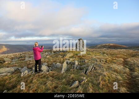 Walker saisissant une photo du Cairn sur Artlecrag et la vue du Nord vers Selside, Lake District, Cumbria, Royaume-Uni Banque D'Images