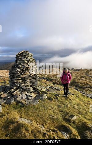 Walker sur Artlecrag Pike avec la vue vers le Mist Shrouded Mountains of High Howes et Selside Pike, Lake District, Cumbria, Royaume-Uni Banque D'Images