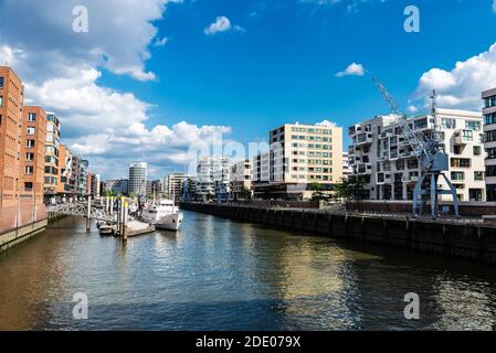 Bâtiments modernes et jetée avec bateaux et grues à côté d'un canal à HafenCity, Hambourg, Allemagne Banque D'Images