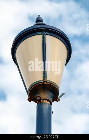 Gros plan d'une lampe de rue rouillée avec peinture bleue écaillée. Banque D'Images