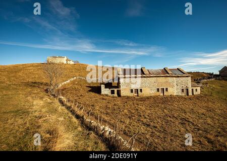 Vieux hangars de vache et pâturages bruns en automne sur le plateau de Lessinia (Altopiano della Lessinia), Parc naturel régional, province de Vérone, Vénétie, Italie, UE. Banque D'Images