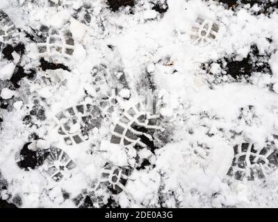 au-dessus de la vue des empreintes texturées dans la première neige surface du terrain de jeu extérieur en gros plan le jour d'automne froid Banque D'Images