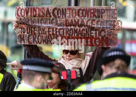 Le manifestant tient une bannière devant la police lors de la manifestation contre la vaccination, Bureau de la Fondation Bill et Melinda Gates, Londres, 24 novembre 2020 Banque D'Images