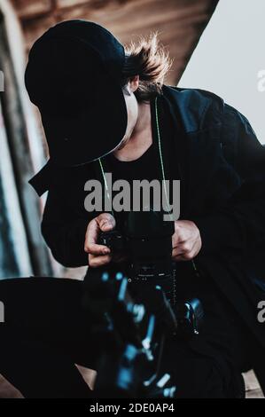 L'opérateur long cheveux vérifie les paramètres de la caméra à l'extérieur Banque D'Images