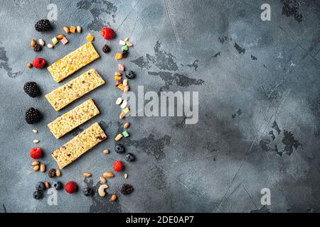 Barres de petit-déjeuner superfood avec noix d'avoine et baies, vue du dessus avec espace de copie, sur fond gris Banque D'Images