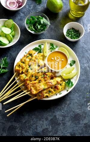 Satay de poulet avec sauce aux arachides. Brochettes de poulet grillées servies avec sauce à la sauce aux cacacahuètes. Repas savoureux pour le dîner ou les hors-d'œuvre de fête. Pierre bleue dos Banque D'Images