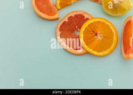 Tranches de pamplemousse, d'orange et de citron sur fond bleu Banque D'Images