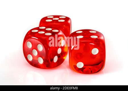 Dés en acrylique rouge transparent pour les jeux. Trois dés translucides de jeu sur fond blanc, gros plan haute résolution. Banque D'Images