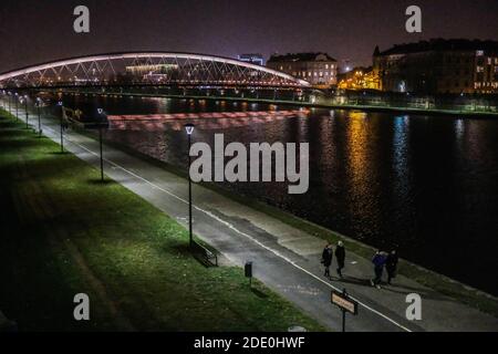 Cracovie, Pologne. 26 novembre 2020. Deux couples ont vu marcher le long d'un boulevard vide et déserté de la rivière Vistule. La Pologne traverse maintenant la deuxième vague de coronavirus et rouvrira des magasins dans les centres commerciaux afin de stimuler l'économie. Crédit : SOPA Images Limited/Alamy Live News Banque D'Images