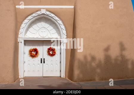 Portes d'entrée blanches sculptées à l'église adobe Mission de San Francisco de Asis - Saint François d'Assissi - à Ranchos de Taos, Nouveau-Mexique, Etats-Unis Banque D'Images