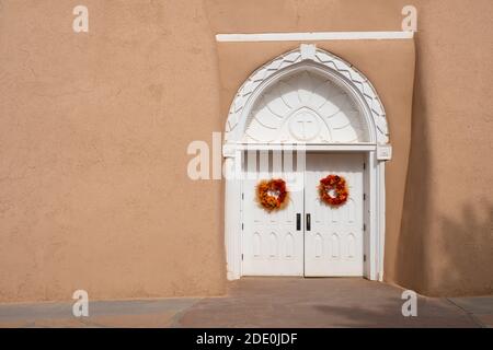 Portes d'entrée blanches sculptées à l'église adobe Mission de San Francisco de Asis - Saint François d'Assissi - à Ranchos de Taos, Nouveau-Mexique, Etats-Unis Banque D'Images