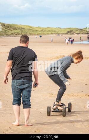 jeune couple s'amusant sur le long surf cerf-volant Plage de Druridge Bay à Northumberland Banque D'Images