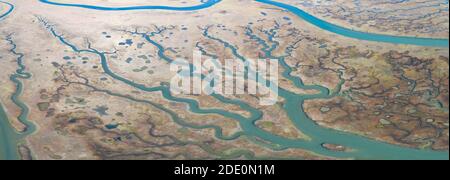 Des canaux sinueux traversent un magnifique estuaire en Californie centrale. Les estuaires se forment lorsque le ruissellement d'eau douce se rencontre et se mélange à l'eau de mer. Banque D'Images